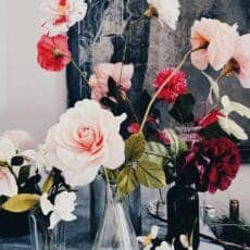 a bunch of vases with red and pink flowers for mothers day.