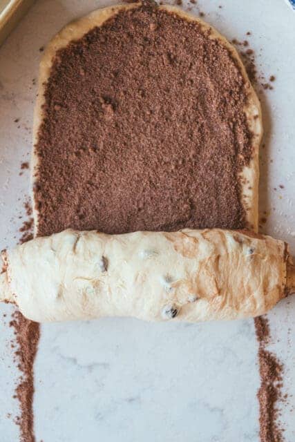 rolling the cinnamon swirl into the raisin bread dough