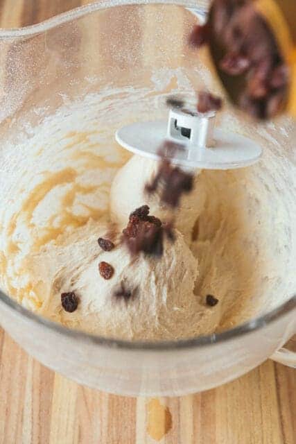 adding raisins into the mixer for cinnamon swirl bread