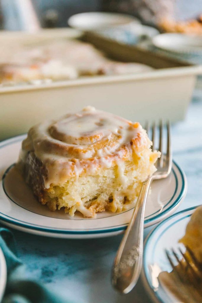 Orange roll on a plate with a fork.