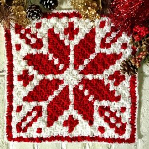 Christmas wall decor with red and white cross-stitch pattern.