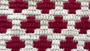 Woven textile featuring red and beige geometric patterns by Juniper and Oakes.
