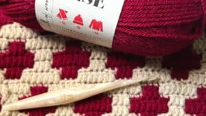 Yarn with Juniper and Oakes branding, featuring red and cream colors.