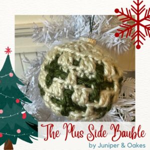 Christmas crochet bauble with green and cream yarns.