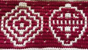 Handwoven rug featuring geometric patterns in red and white.