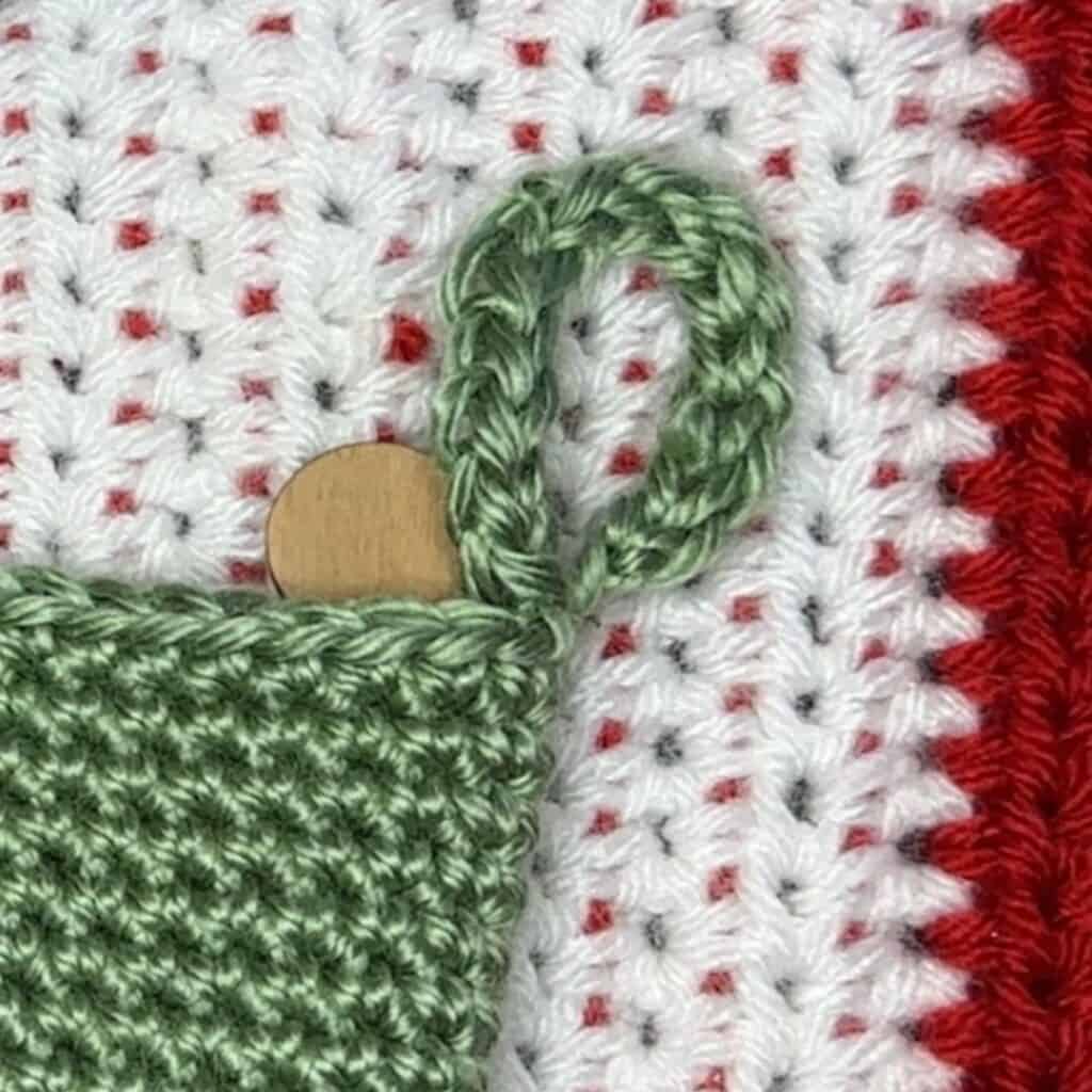 Beautiful green and white crochet Christmas stocking with a loop for hanging, perfect for holiday de.