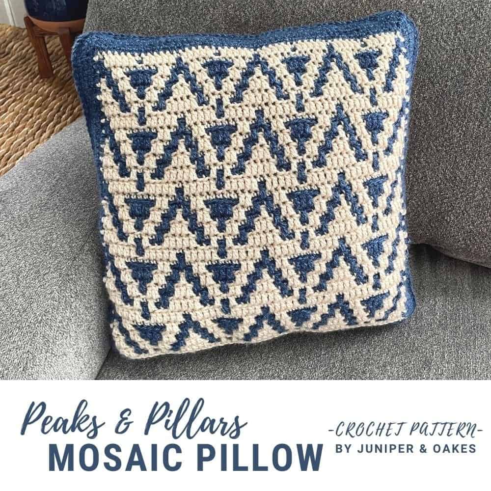 Decorative mosaic crochet pillow with blue and white geometric squares design.