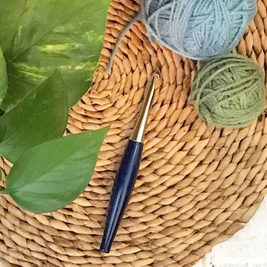 Cabled granny pillow made with Bernat Blanket Yarn, perfect for cozy home decor.