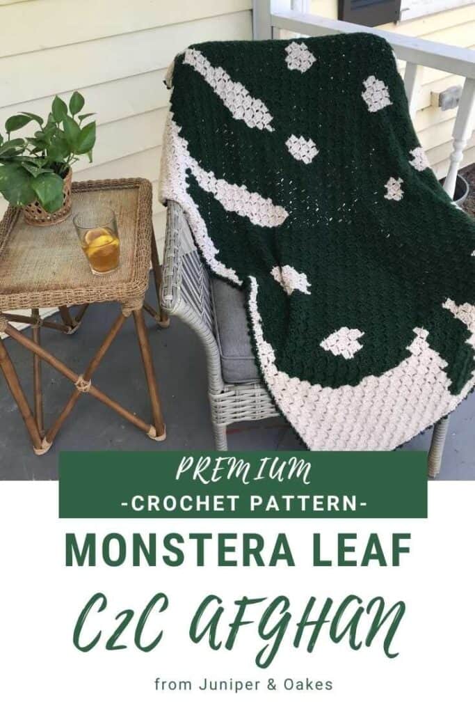 Monstera leaf crochet blanket on porch chair with side table and plant.