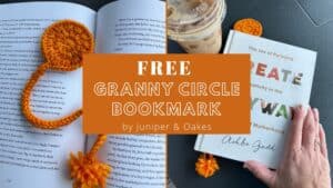 Granny circle crochet bookmark with orange yarn, placed on an open book.