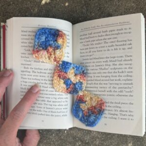 Crochet slippers made with multicolored yarn on an open book.