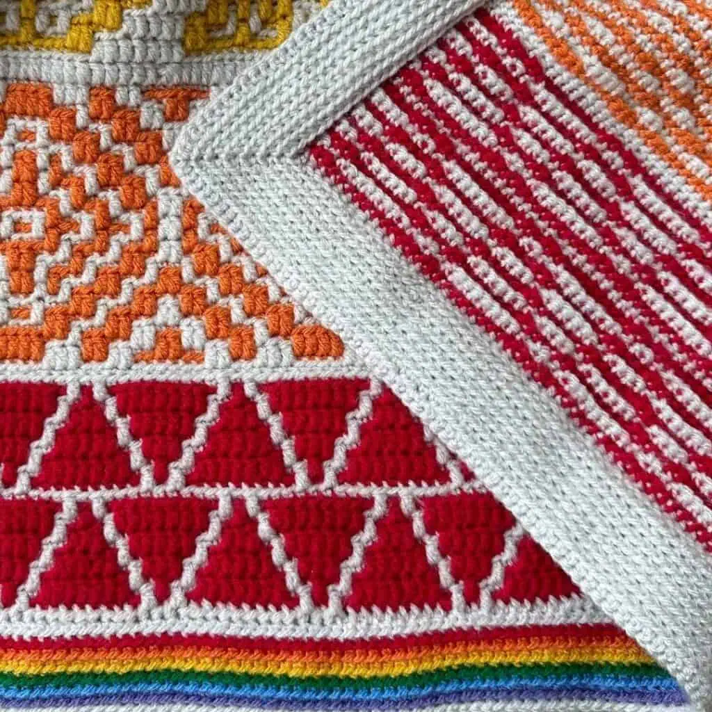 Rainbow envelope border of a overlay mosaic crochet blanket. This picture depicts both sides of the blanket and border.