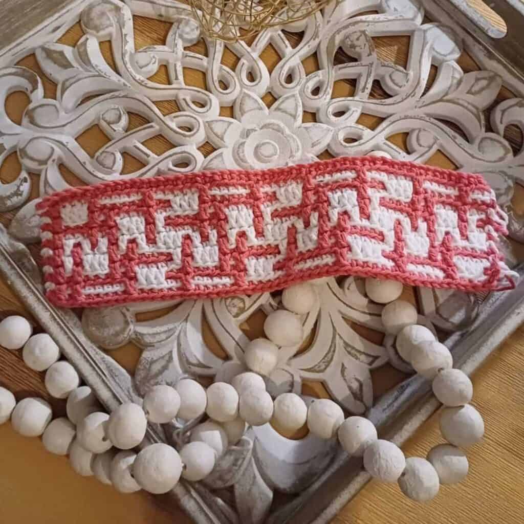 Geometric mosaic crochet blanket with pink and white pattern, perfect for crochet along projects.