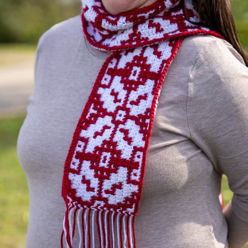 Festive red and white mosaic crochet scarf with intricate holiday design, perfect for Christmas cele.
