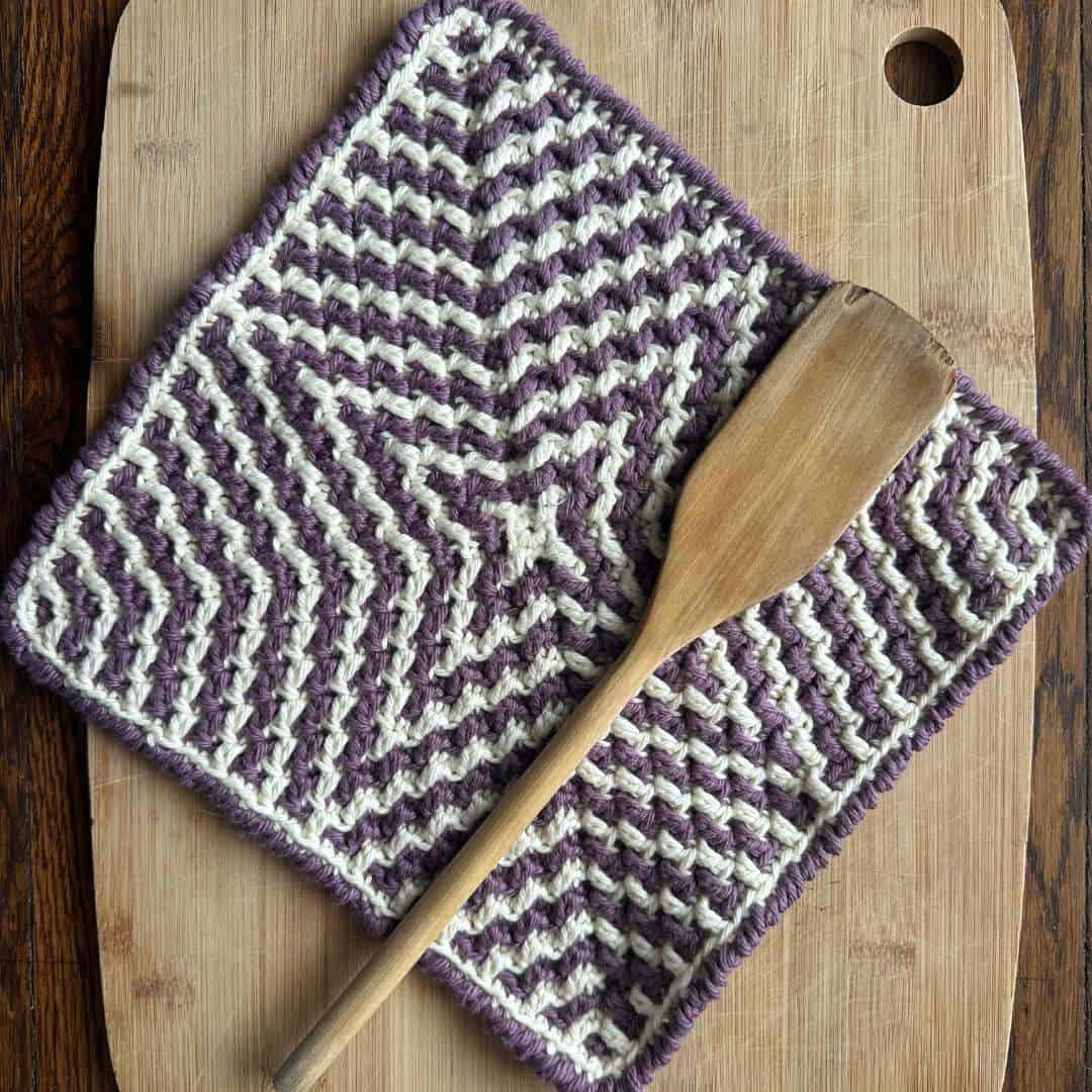 Handmade starburst mosaic crochet washcloths in purple and white.
