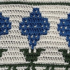 Up of a mosaic crochet sunflower design in blue and green yarns.