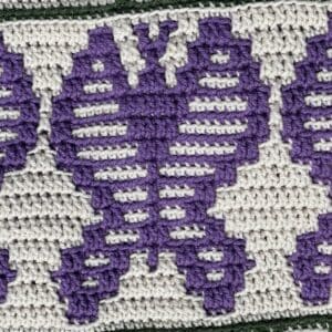 Detailed alt text: Close-up of a sunflower mosaic crochet pattern featuring purple and white yarns,.