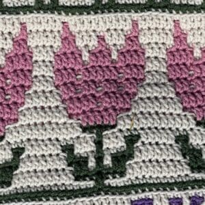 Close-up of pink sunflower mosaic crochet pattern with detailed stitches.