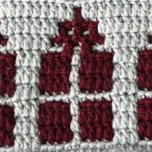 Close-up of a festive crochet mosaic pattern with red and white yarns.