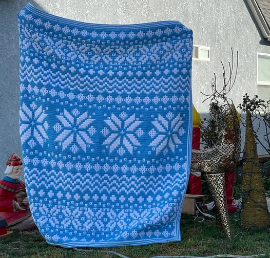 Crochet Nordic star mosaic blanket featuring intricate snowflake patterns, perfect for winter decor.