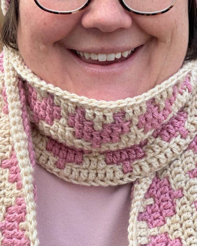 Crochet heart mosaic scarf featuring pink and cream colors, perfect for cozy winter wear.