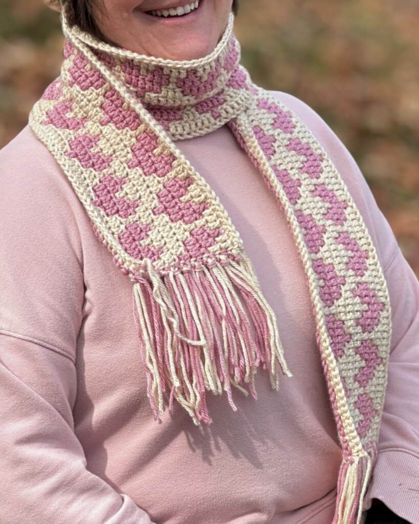 Crochet mosaic hearts scarf in pink and cream, perfect for cozy winter wear.