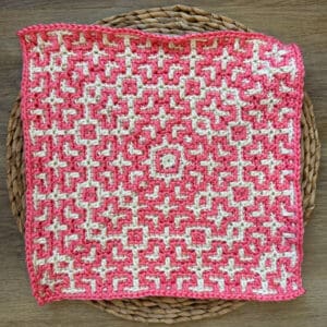 Crochet mosaic square with Celtic knot pattern in pink and white.