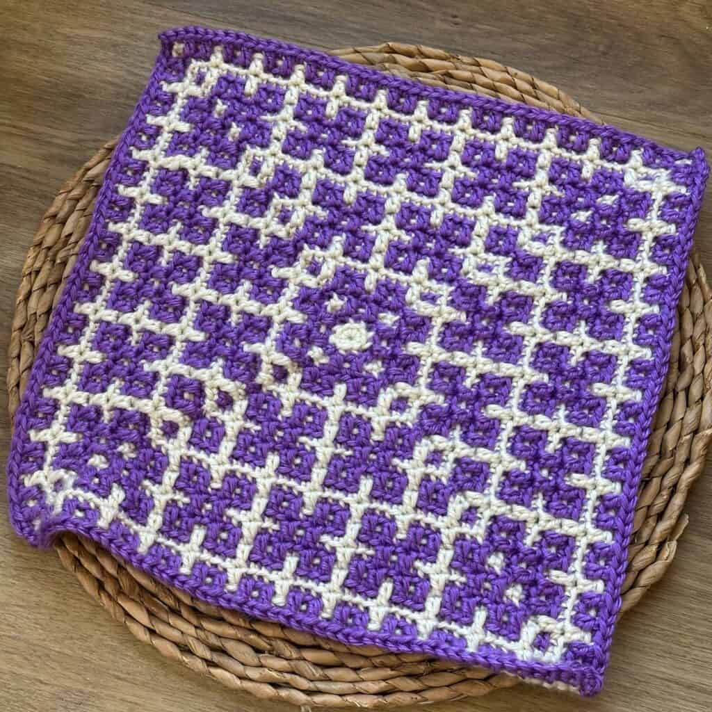 Crochet mosaic square featuring purple and white dogwood flower pattern. Perfect for afghans or other projects.