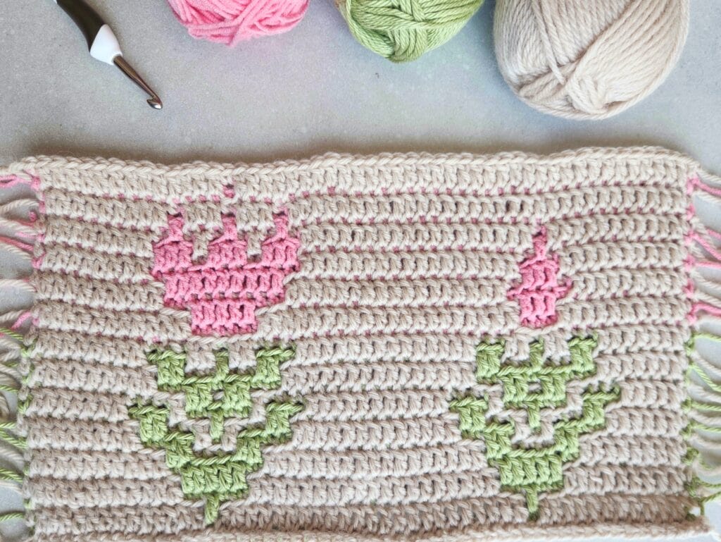 Mosaic crochet blanket motif with pink and green floral pattern, perfect for summer decor.