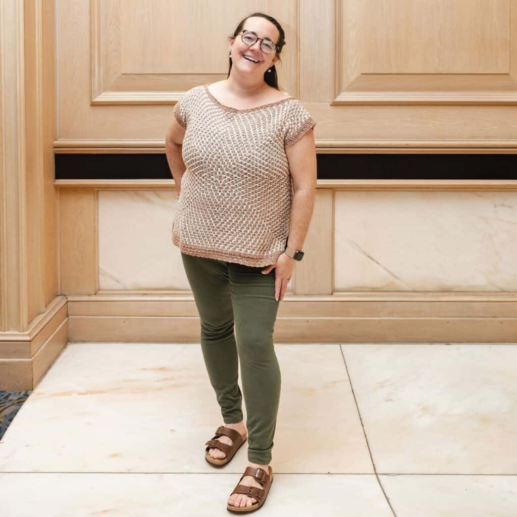 Erin wearing the mosaic crochet starburst sweater tee, standing indoors.