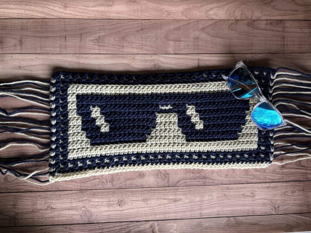 Black and gray mosaic crochet sunglasses motif on a wooden surface