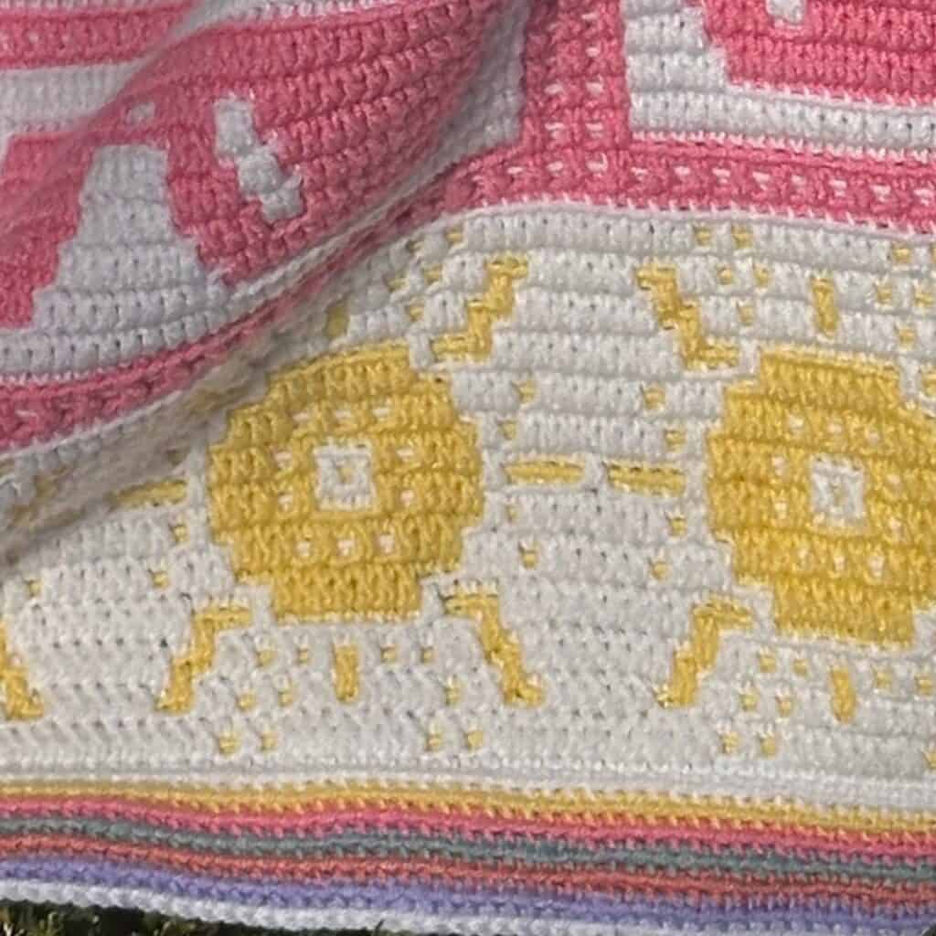 Bright mosaic crochet sunshine blanket with colorful stripes and sun motifs.