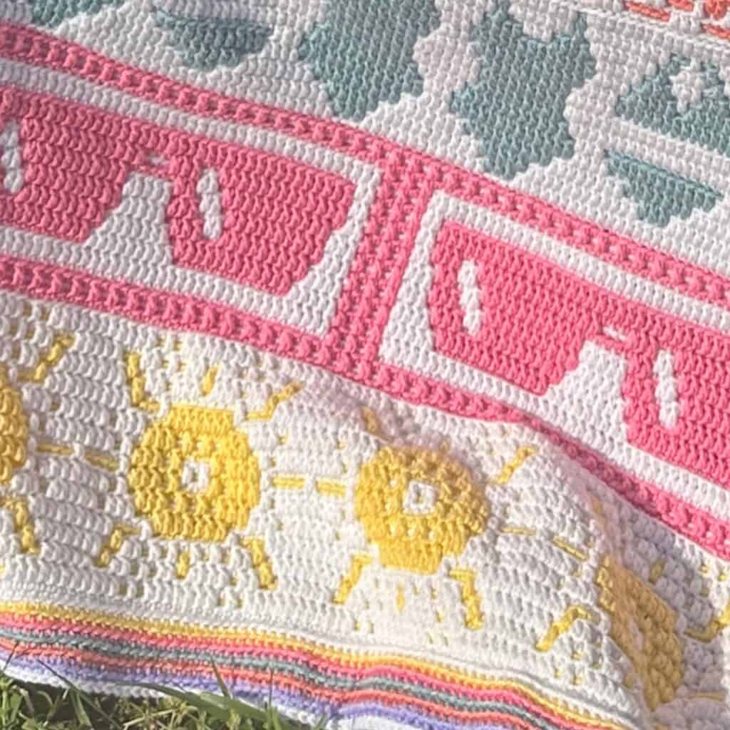 Bright mosaic crochet sunshine blanket with colorful sun and stripe patterns.