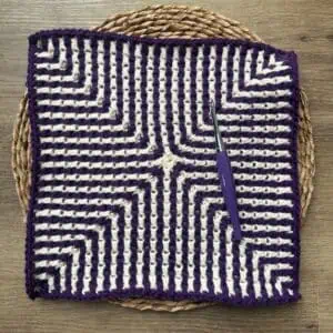 Crochet square with purple and white mosaic design, perfect for crochet projects.