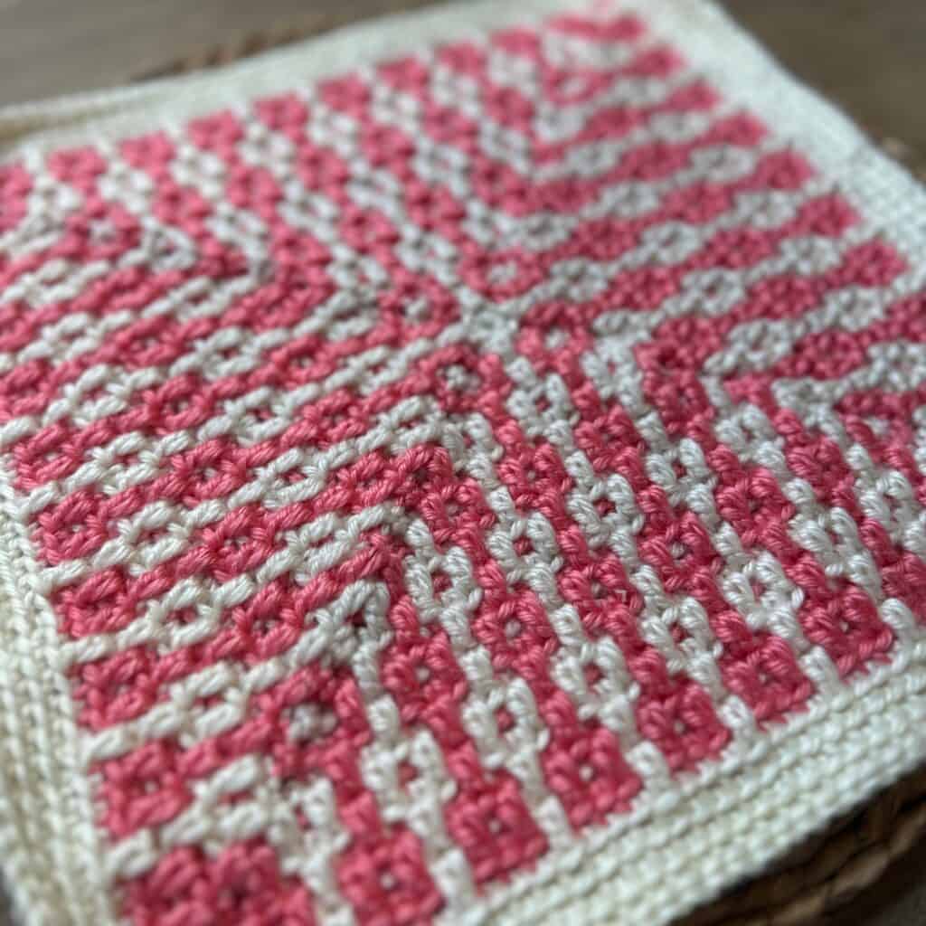 Close-up of the Patterned Pillars crochet square design in pink and white.