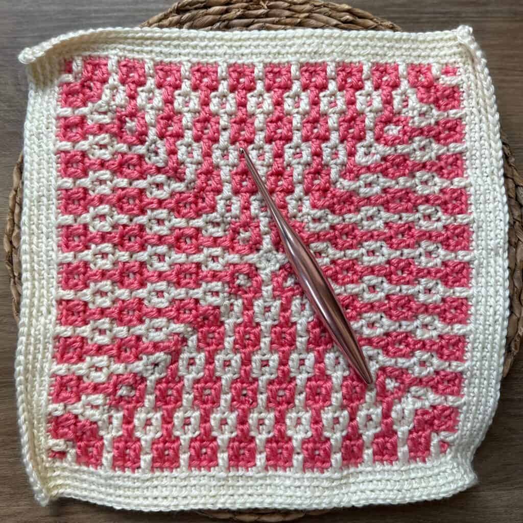 Crochet textile featuring pink and white geometric pillar patterns, inspired by architectural motifs.
