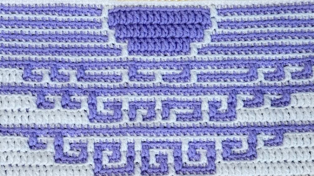 Beautiful mosaic crochet blanket strip featuring a sunset over the water in purple and white.
