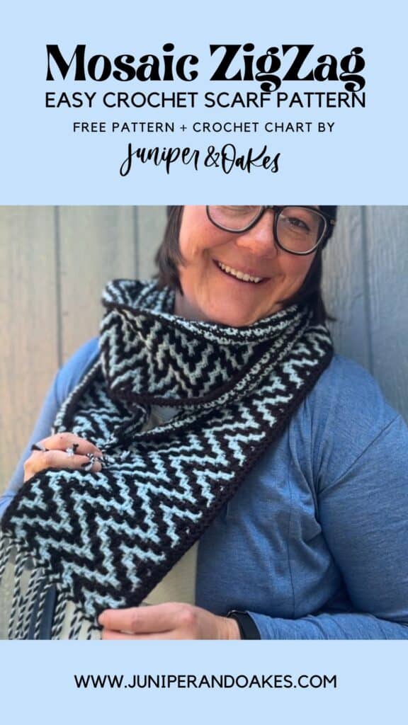 Woman wearing a black and white Mosaic ZigZag crochet scarf, smiling.