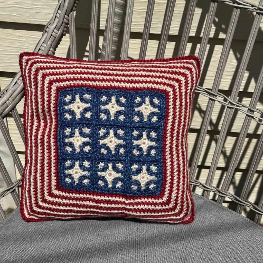 Patriotic mosaic crochet pillow with stars and stripes in red, white, and blue colors for the 4th of July.