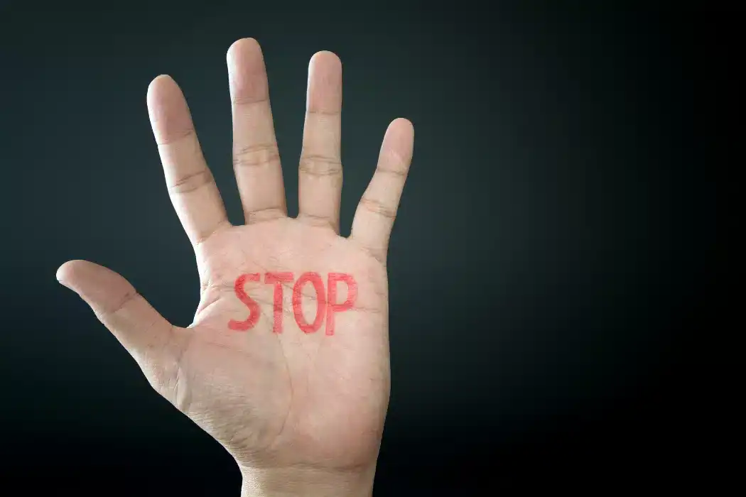 Hand with "STOP" written in red, symbolizing a protest or warning.