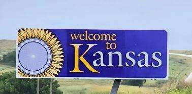 Travel in Kansas-Welcome to Kansas highway sign against a beautiful blue sky