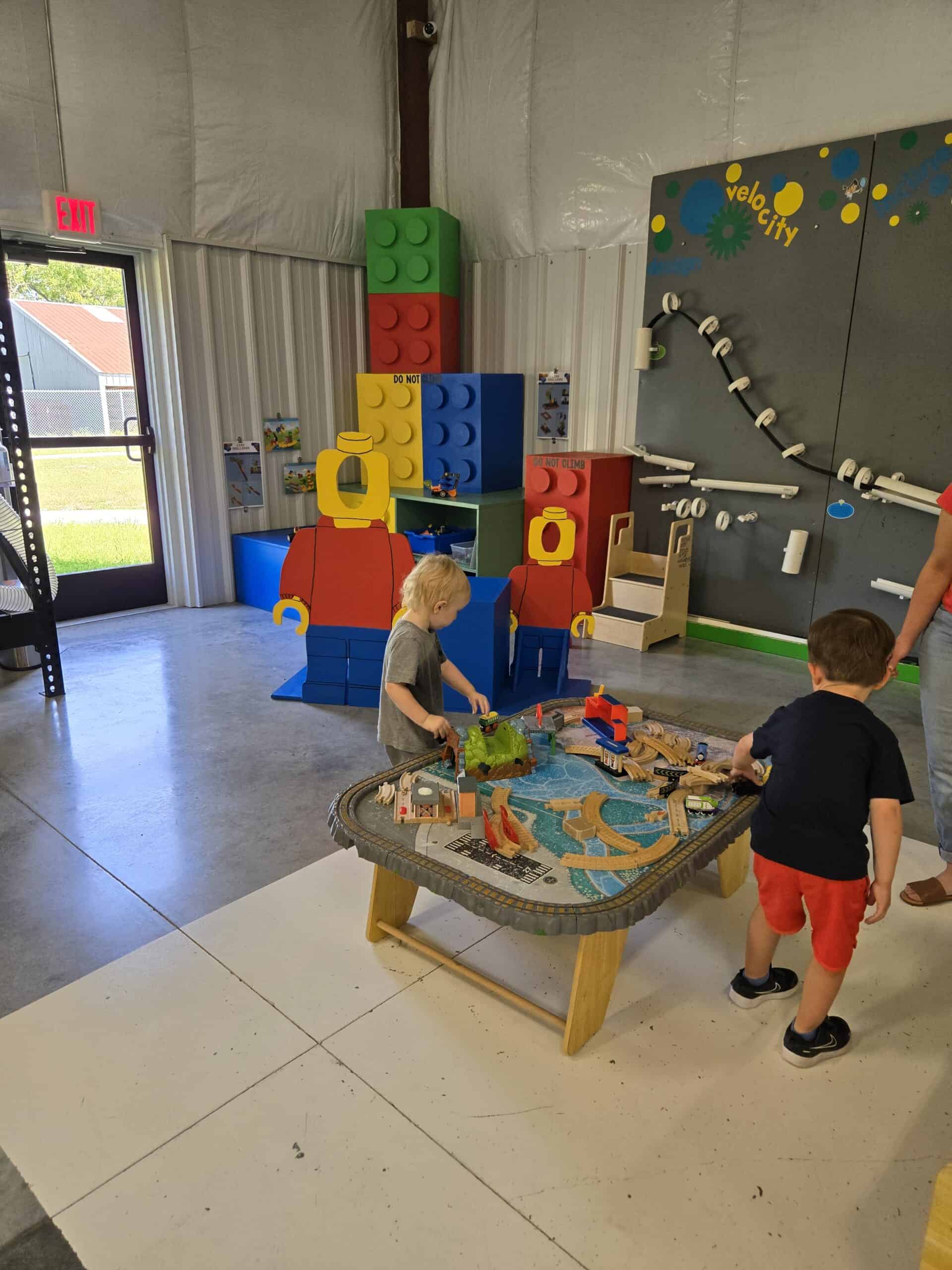 Two children playing with a toy train table at Curious Minds Discovery Zone in Parsons KS-One of tthe 15 Best Things to do with Kids in Parsons Kansas
