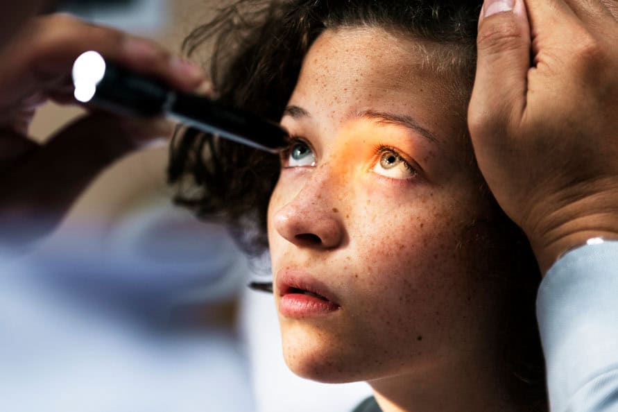 Close-up of a young girl receiving an eye examination for keratoconus diagnosis.