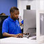 IT technician working on a computer in a modern office setting.
