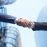 Two professionals shaking hands in a corporate setting.