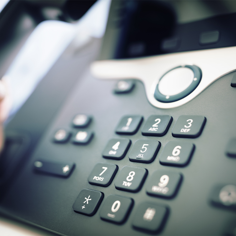 Close-up of office phone keypad and control panel.