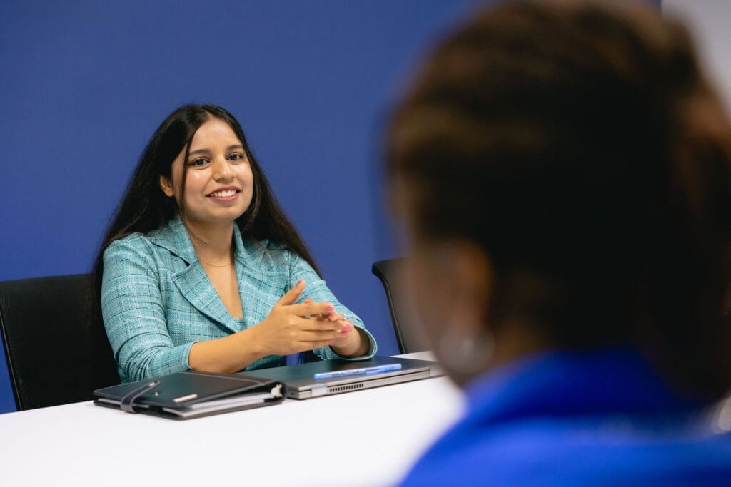 Woman smiling during a business meeting in a modern office setting.