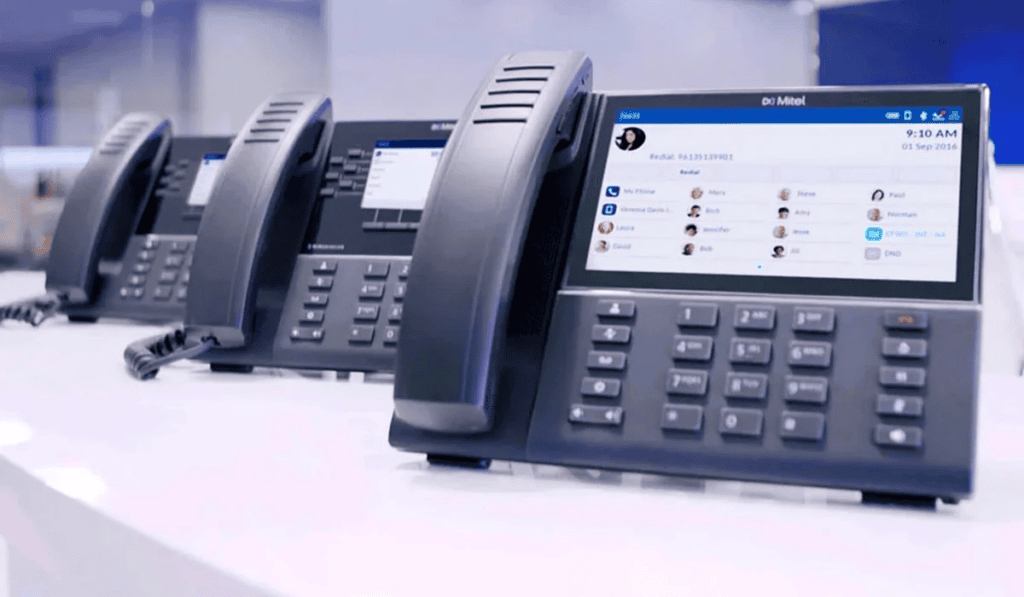 Modern office telephones with digital display screens for business communication.