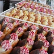 Delicious Knead Donuts featuring chocolate, cream, and pink toppings, perfect for any sweet craving in NZ.