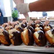 Delectable donuts topped with creamy frosting and chocolate glaze, freshly made at Knead Donuts.